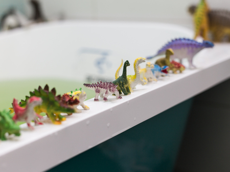a lot of different toy dinosaurs at the bathroom.の写真素材