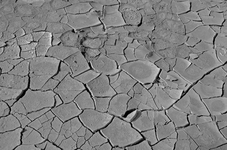 Dark gray background of dry cracked earth in the desert of Israel. Concept: no rain, drought, dry...