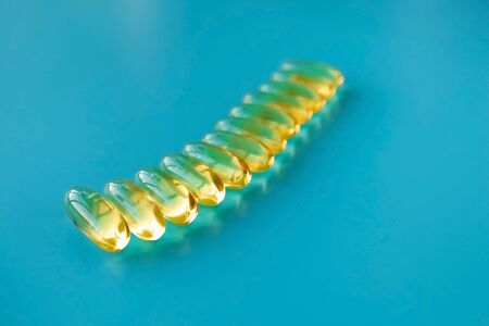 handful of omega 3 capsules on a blue backgroundの写真素材