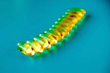 handful of omega 3 capsules on a blue backgroundの写真素材