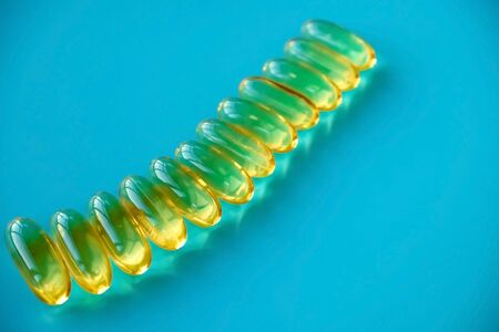 handful of omega 3 capsules on a blue backgroundの写真素材