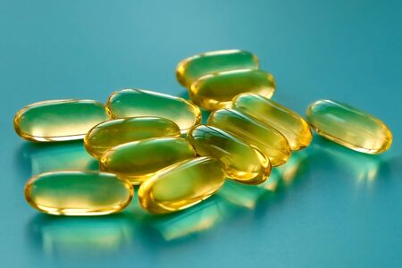 handful of omega 3 capsules on a blue backgroundの写真素材