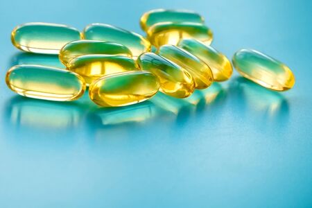 handful of omega 3 capsules on a blue backgroundの写真素材
