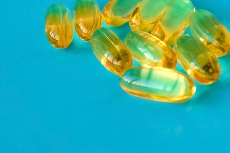 handful of omega 3 capsules on a blue backgroundの写真素材