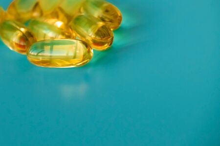 handful of omega 3 capsules on a blue backgroundの写真素材