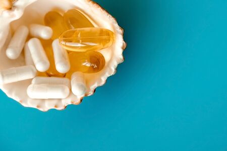 Omega 3 and vitamin D capsules on shell, fish oil pills.の写真素材