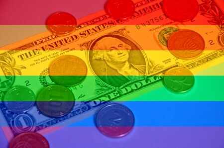 Coins 1 and 2 Israeli shekel and 10 agorot lie on one American dollar. A paper banknote and coins on a blue background.の写真素材