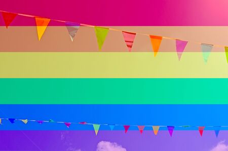 Rope with colored flags hanging on a blue sky background. LGBT natural pattern, Vintage texture background, Abstract paintingの写真素材