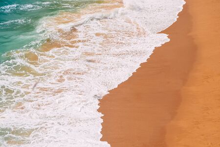 Raging ocean, azure coast with a golden sandy beach. Top view, drone view Benagil Beach in Portugal