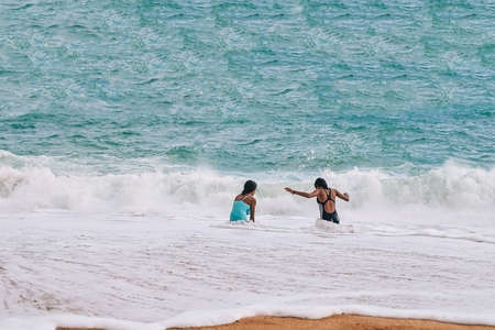 tanned children in a swimsuit on the beach play on the sand. Atlantic coast, Benagil beach in...