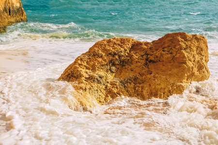 Waves crash on rocks in the atlantic ocean at benagil beach in portugal