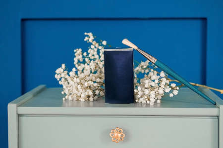 Blue box of cosmetics with flowers on the beautician's table. Template for advertising