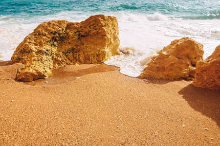 Waves crash on rocks in the atlantic ocean at benagil beach in portugalの写真素材