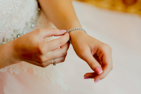 girl puts on a bracelet with stones, morning of the brideの写真素材