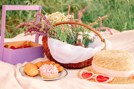 hat and glasses, croissants with donuts on a plate. girl on a picnic in the spring park.の写真素材