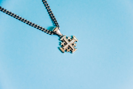 Jerusalem silver crusader cross with chain on a blue background.の写真素材