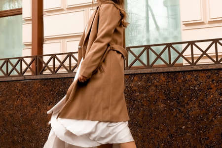 girl in brown coat and beige dress is spinning in the streetの写真素材