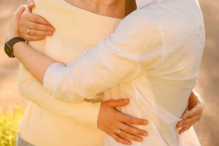 a guy and a girl stand next to each other, hold hand by hand and hug, horizontal imageの写真素材