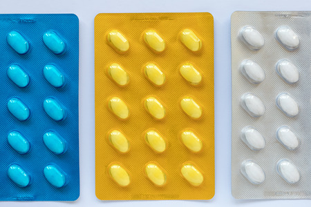 Set of various tablets in a blue, yellow and white pack blister pack. Healthcare and medical...