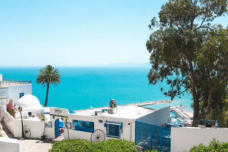 Sidi Bou Said, Tunisia - May 19, 2017: View of the street with white and blue traditional architecture, sea in the background. Blue sky, copy space.のeditorial素材