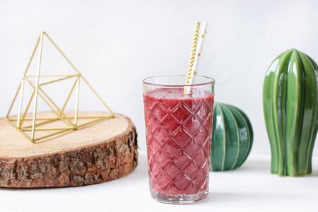 Red beet, blueberry and strawberry smoothie in a glass. Vegan healthy food concept. Copy space, selective focus.の写真素材