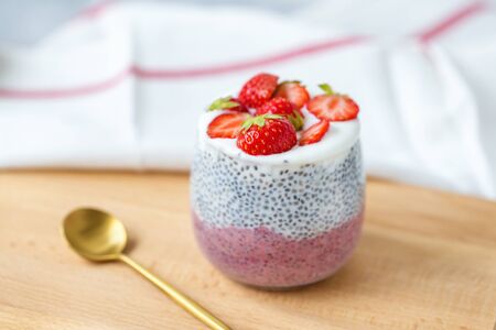 Chia pudding with almond milk, yogurt, pitaya powder and strawberries. Vegan concept.の写真素材