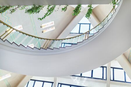 Hurghada, Egypt - July 5, 2019: Fragment of interior in lobby of Pharaoh Azur Resort Hotel. Pyramid shaped roof with windows, staircase and greenery.のeditorial素材