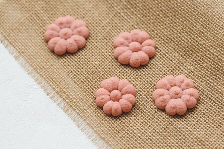 Flower cookies on rustic cloth. Spring holidays cooking concept, flatlay, copy space.