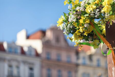 Easter outdoor flower decorations on the streets of Prague, blurred historical buildings background,...