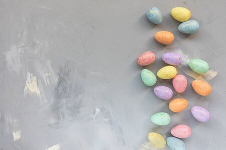 Pastel and gold colored eggs decoration on a gray background. Easter celebration concept. Top view,...