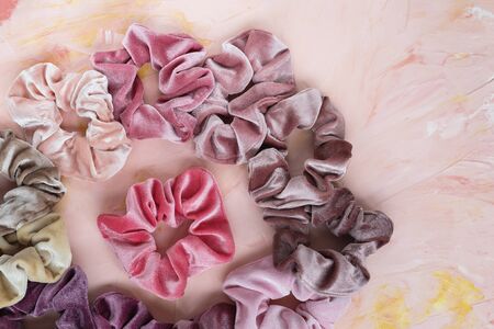 Collection of trendy velvet scrunchies on pink background. Diy accessories and hairstyles concept, copy spaceの写真素材