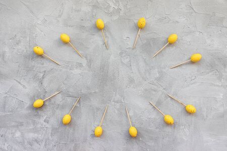 Yellow Easter wooden sticks for finger food on a gray background. Easter party food decoration concept. Top view, flat lay, copy spaceの写真素材