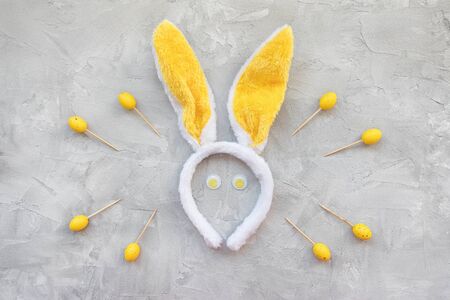 Yellow Easter wooden sticks for finger food and bunny ears on gray background. Easter party food...