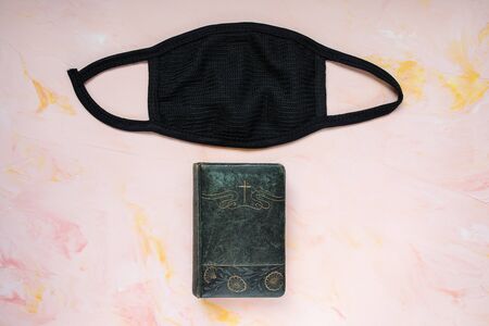 Covid-19 quarantine christian background. Bible and mask on pink. Coronavirus outbreak stay home...