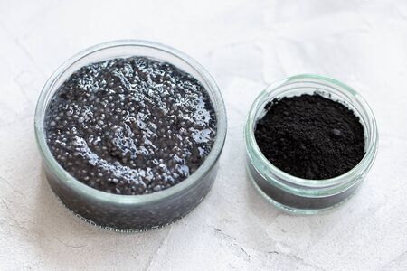 Black chia seed pudding with activated charcoal powder, dessert in a glass. Superfood, vegan, vegetarian food, detox concept. Gray background. Copy space, closeup, selective focusの写真素材