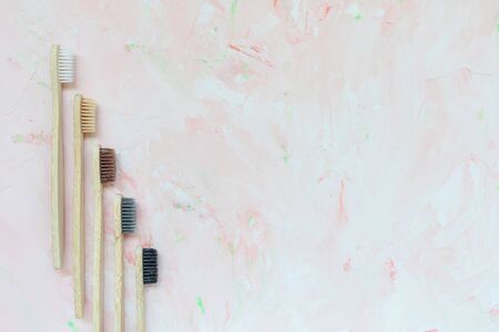 Five different natural wooden bamboo toothbrushes. Plastic free and zero waste concept. Top view,...