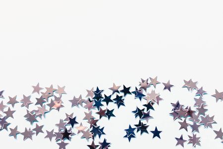 Winter abstract backround with silver foil confetti stars on white. Birthday party, New Year, Christmas celebration, holidays, winter and dreams concept. Copy spaceの写真素材