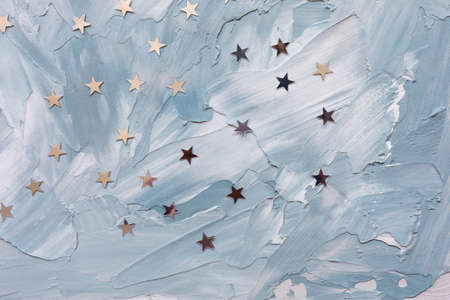 Trendy silver foil confetti stars on white and blue background. Christmas festive abstract...