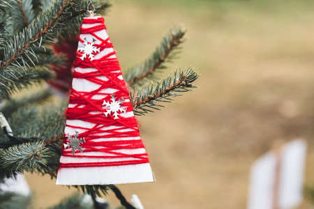 Wool and paper handmade decoration on a Christmas tree outdoor. Diy yarn crafts creative ideas for...