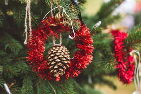 Gold painted pine cone on Christmas tree. Diy decoration ideas for children. Environment, recycle,...