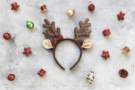 Moody winter holidays red and white background with deer costume handband and holiday decoration. Festive abstract backround. Christmas celebration, New Year party conceptの写真素材