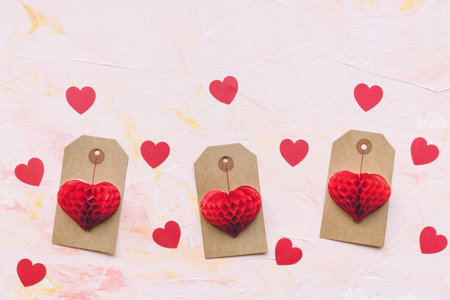 Romantic pink backround with red paper hearts decoration and label tags. Love, dating, Valentines...