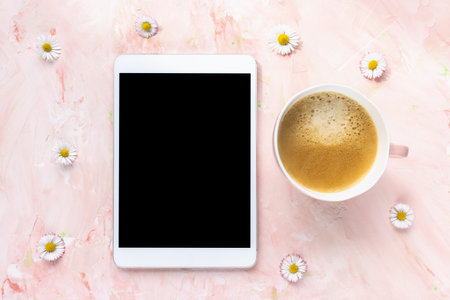Digital tablet and spring or summer flowers, pastel pink background. Online shopping, studying, sales mock up. Minimalist flat lay, top view, copy space. Internet application template.の写真素材