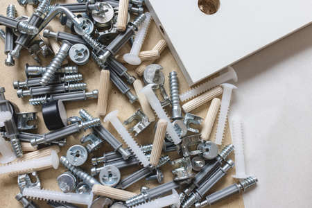 Opened box with furniture assembly parts and tools on the floor. Self assembling and DIY furniture...