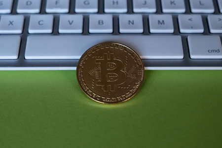 One golden bitcoin on a keyboard. Cryptocurrency and business financial concept. Close-up.の写真素材