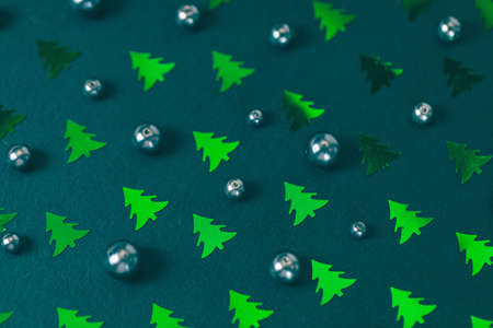 Black pearls and Christmas tree foil confetti on green creative abstract backround. Winter, Christmas, New Year celebration concept. Holiday flat layoutの写真素材