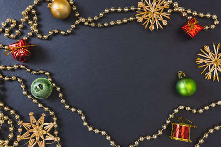 Christmas straw snowflakes, baubles and other decoration on black festive background. Winter holidays concept. Flat lay, top view, copy spaceの写真素材