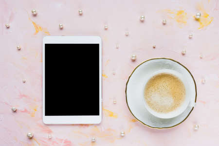 Digital tablet mock up, cup of espresso on pastel pink with pearls abstract woman background. Coffee...