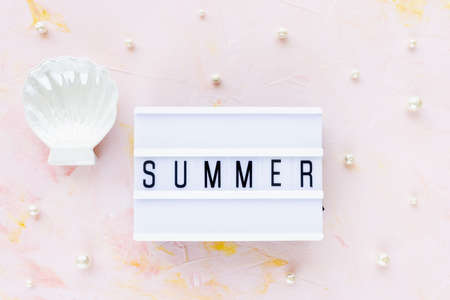 Word SUMMER on pink with seashell decoration and white pearls background. Sea vacation, holiday concept, flat lay, top view, copy spaceの写真素材