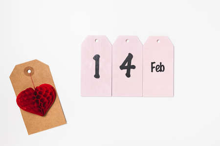 Price tag with red heart and text 14 Feb. Valentines Day gift shopping concept, holiday flat lay, copy spaceの写真素材